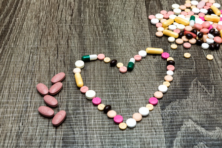 colorful pills in the shape of the heartの写真素材