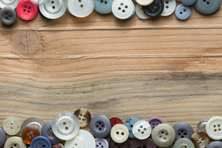 colored buttons on wooden board, Colorful buttons, on old wooden texture backgroundの写真素材