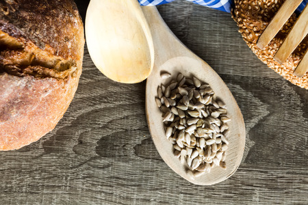 Seeds in Wooden Spoon Spread on Wood Background with Table Cloth.の写真素材