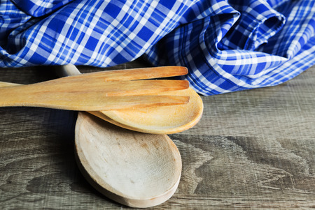 Wooden Kitchen Utensils on wooden background. Spoon,  fork and towelの写真素材
