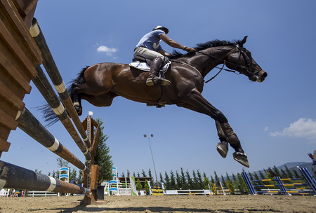 THESSALONIKI, GREECE, JUNE 14, 2015: Unknown rider on a horse during competition matches riding round obstaclesのeditorial素材
