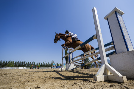 THESSALONIKI, GREECE, JUNE 14, 2015: Unknown rider on a horse during competition matches riding round obstaclesのeditorial素材