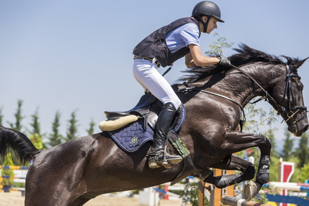 THESSALONIKI, GREECE, JUNE 14, 2015: Unknown rider on a horse during competition matches riding round obstaclesのeditorial素材