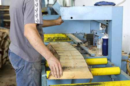 Thessaloniki, Greece, July 8, 2015: Craftsmen cut a piece of wood at a woodworking factory in Greece. Wood and furniture production plant, industrial factory with tools and objects.のeditorial素材