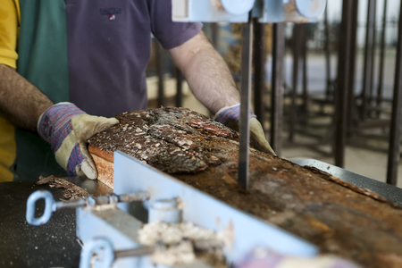 Thessaloniki, Greece, July 8, 2015: Craftsmen cut a piece of wood at a woodworking factory in Greece. Wood and furniture production plant, industrial factory with tools and objects.のeditorial素材
