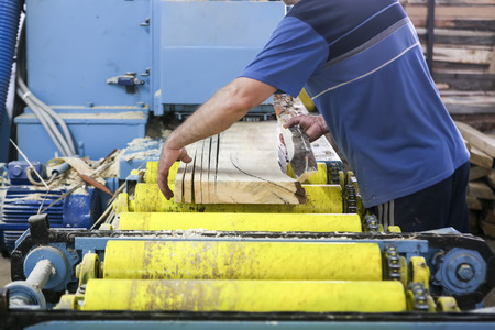 Thessaloniki, Greece, July 8, 2015: Craftsmen cut a piece of wood at a woodworking factory in Greece. Wood and furniture production plant, industrial factory with tools and objects.のeditorial素材