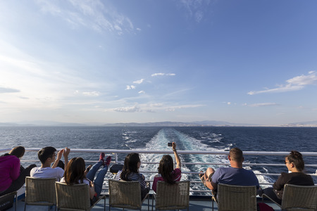 Santorini, Grece- May 12, 2015: Tourists sitting on the deck of a ship heading to Santorini island, in Greece.のeditorial素材