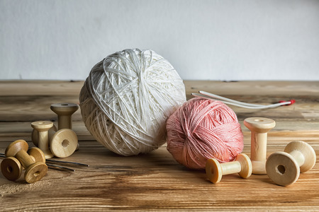 Spools of thread on wooden  background. Old sewing accessories.