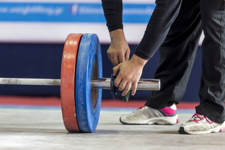 Thessaloniki, Greece, Oct 3 2015: Hands on the barbell. Young athlete getting ready to lift the weights during the course of the Greek Weightlifting Championshipのeditorial素材