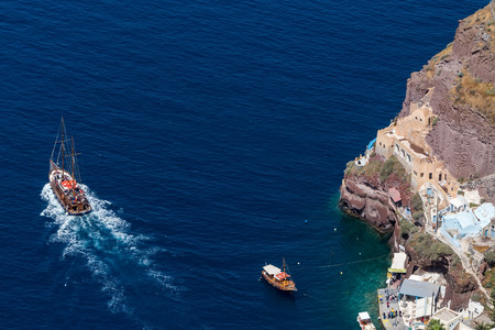 Santorini, Grece- May 13, 2015: Yacht navigates into beautiful blue water near Santorini island, Aegean sea in Greece.のeditorial素材