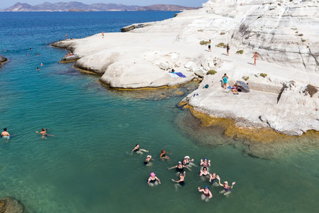 Milos, Greece - September 9, 2015: Tourists enjoy the clear water of Sarakiniko beach in Milos, Greece. This beach is one of the most beautiful beaches of Milos and surely the most particular one.のeditorial素材