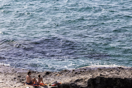 Milos, Greece - September 8, 2015: Tourists enjoy the clear water of the beautiful beach in Milos island, Cyclades, Greeceのeditorial素材