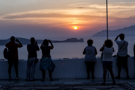 Milos, Greece - September 8, 2015: Tourist taking pictures with their cameras or phones of the beautiful sunset at Milos island, Greece.のeditorial素材