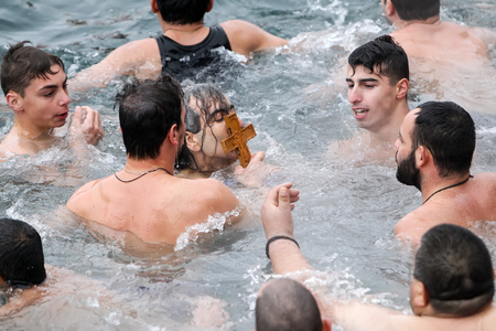 Thessaloniki, Greece, January 6, 2016: A swimmer kisses a wooden cross retrieved from the sea, during the blessing of the water ceremony marking the Orthodox Epiphany Day, in port of Thessalonikiのeditorial素材