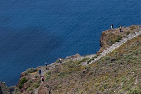 Santorini, Greece- May 15, 2015: Tourists walking up the stairs to visit the church on the mountain...