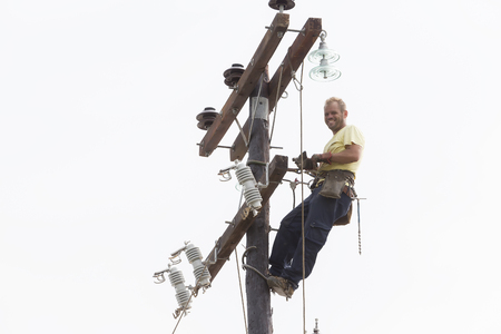 Thessaloniki, Greece- September 24, 2015: Worker climbing on Electrical concrete pole transmission line tower in Thessaloniki, Greece.のeditorial素材