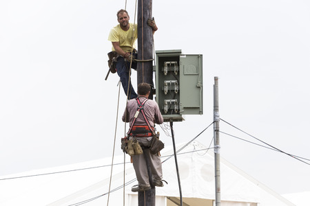 Thessaloniki, Greece- September 24, 2015: Workers climbing on Electrical concrete pole transmission line tower in Thessaloniki, Greece.のeditorial素材