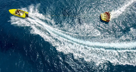 Ios, Greece - September 19, 2015: Tourists having fun on inflatable watercraft boat at the beautiful ocean of Greek island of Ios island, Cyclades, Greece.のeditorial素材