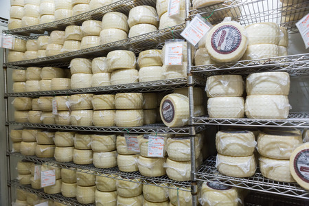 Ios, Greece - September 19, 2015: Cow milk cheese, stored in a wooden shelves and left to mature at a Greek factory in Ios island, Cyclades, Greece.のeditorial素材