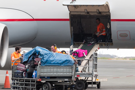 Thessaloniki, Greece - June 18, 2015: People loading luggage on the plane to the airport macedonia a rainy dayのeditorial素材
