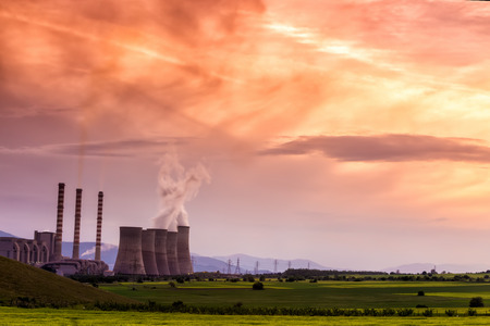 Electric power plant at dusk with orange sky in Kozani Greeceのeditorial素材