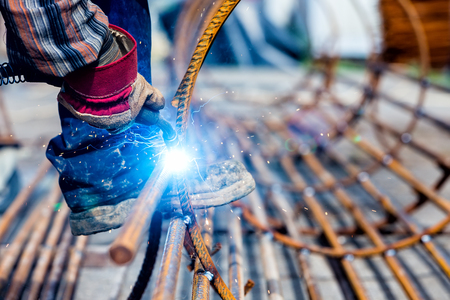 Close up of the hands welder worker with electrode. selective focus