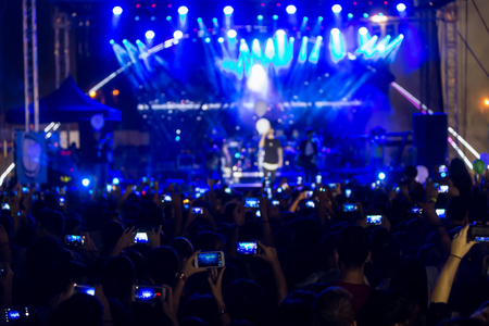 Hand with a smartphone records live music festival, Taking photo of concert stage, live concert, music festival, happy youth, luxury party, landscape exterior.のeditorial素材