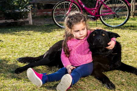 Young girl with dog playing in gardenの写真素材