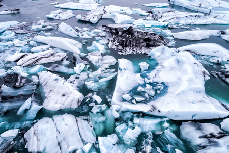 Aerial view of icebergs floating in Jokulsarlon Lagoon by the southern coast of Iceland. Soft focus. Image taken with action drone camera causing distortion and blur.の写真素材