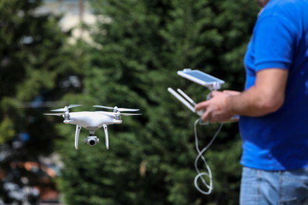 Controlling a remote helicopter drone. Drone flight remote controller in man hands