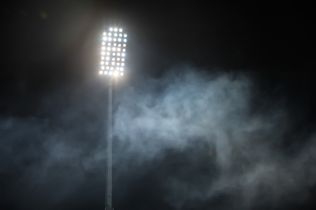 stadium lights and smoke against dark night sky backgroundの写真素材