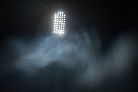 stadium lights and smoke against dark night sky backgroundの写真素材