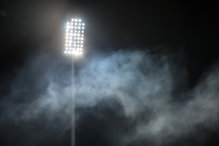 stadium lights and smoke against dark night sky backgroundの写真素材