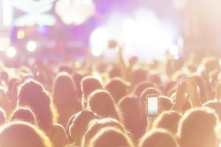 Hand with a smartphone records live music festival, Taking photo of concert stage, live concert,...