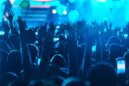 Hand with a smartphone records live music festival, Taking photo of concert stage, live concert,...
