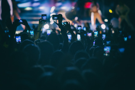 Hand with a smartphone records live music festival, Taking photo of concert stage, live concert, music festival, happy youth, luxury party, landscape exteriorの写真素材