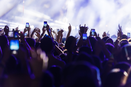 Hand with a smartphone records live music festival, Taking photo of concert stage, live concert, music festival, happy youth, luxury party, landscape exteriorの写真素材