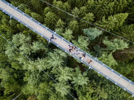 Geierlay, Morsdorf, Germany - July 11, 2017: Holidaymakers cross Germany's longest rope suspension bridge 300 feet above a canyon floor Geierley. It is between the towns of Morsdorf and Sosbergのeditorial素材