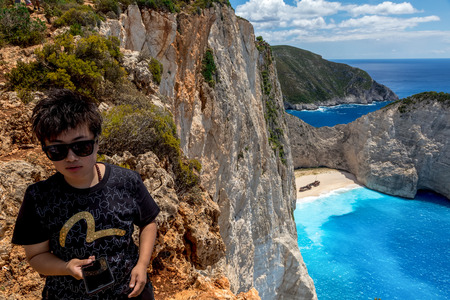 Zakynthos, Greece - July 17, 2017: Travelers on the Background Incredible Navagio (Shipwreck) Beach in Zakynthos island, Greece. Navagio Beach is a popular attraction among tourists visiting the island of Zakynthosのeditorial素材
