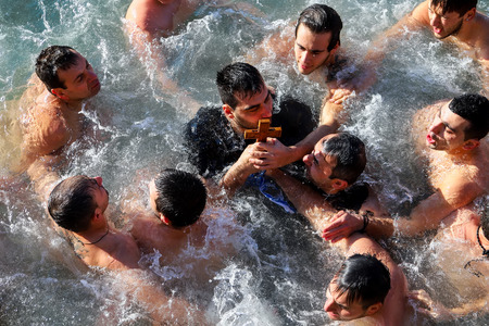 Thessaloniki, Greece, January 6, 2018: A swimmer kisses a wooden cross retrieved from the sea, during the blessing of the water ceremony marking the Orthodox Epiphany Day, in port of Thessalonikiのeditorial素材