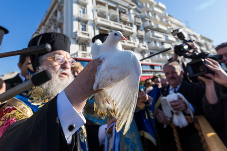 Thessaloniki, Greece, January 6, 2018: Bishop of Thessaloniki Anthimos holds a pigeon, during an Epiphany ceremony to bless the water. This ceremony marks the Epiphany celebrated every year.selective fogusのeditorial素材
