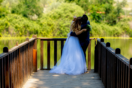 Beautiful wedding couple in park. They hug each other (soft focus).の写真素材