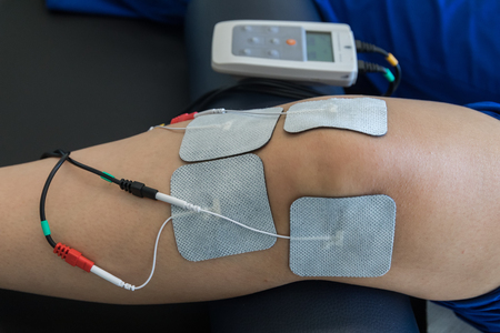 electronic therapy on knee used to treat pain. selective focus