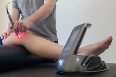 Laser therapy on a knee used to treat pain. selective focusの写真素材