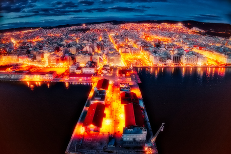 Aerial view of harbor and city Thessaloniki at night, Greece. (Cross processed image with mixed digital effects) Image taken with action drone camera causing distortion and blur.の写真素材
