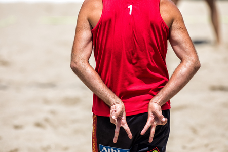 Thessaloniki - Greece June 8, 2018:close up of man buttocks and hands showing beach volleyball hand sign meaning angle attack block during the Hellenic championship Beach Volley Masters 2018 at Aristotelous squareのeditorial素材