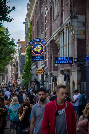 Amsterdam, Netherland - July 7, 2018: Bars and coffee shops on the street full of tourists at night in famous Red Light District in Amsterdam, Netherlands.のeditorial素材