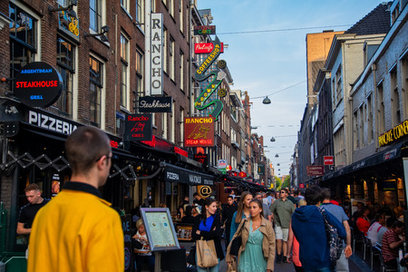 Amsterdam, Netherland - July 7, 2018: Bars and coffee shops on the street full of tourists at night in famous Red Light District in Amsterdam, Netherlands.のeditorial素材