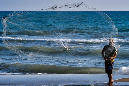 Alpheios, Greece - August 17, 2018: Fisherman casting net during daylight in delta of the river Alpheios in the Peloponnese, in Greeceのeditorial素材