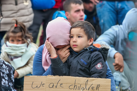 Thessaloniki, Greece - April 6, 2019: The little refugee gives courage to his mother. She just realized that has fallen victim to fake news and canât continue their journey from Greece to Europe.のeditorial素材